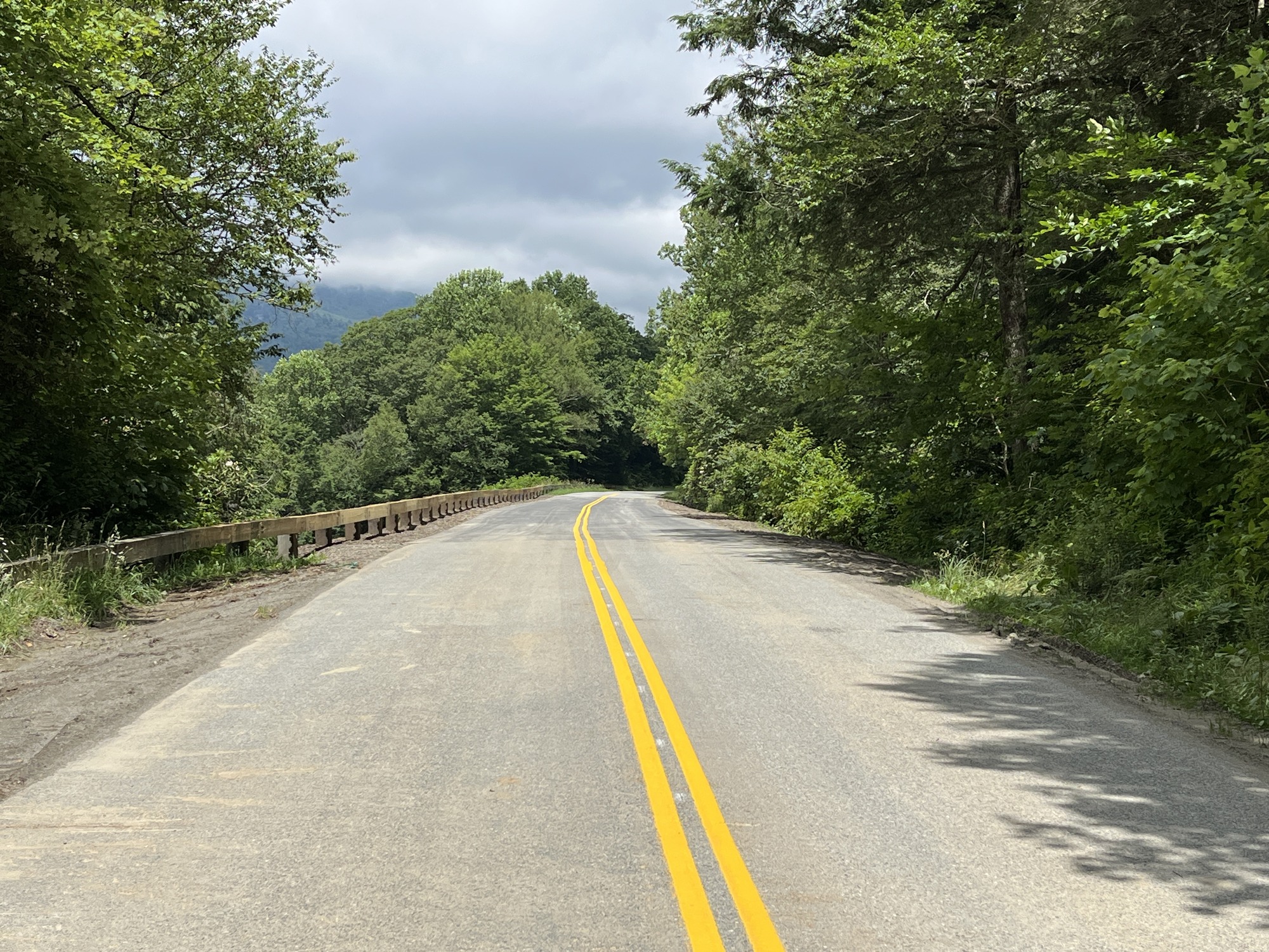Newly paved road covered with dirt tracks from construction equipment at milepost 307 after hurricane Helene damage was repaired