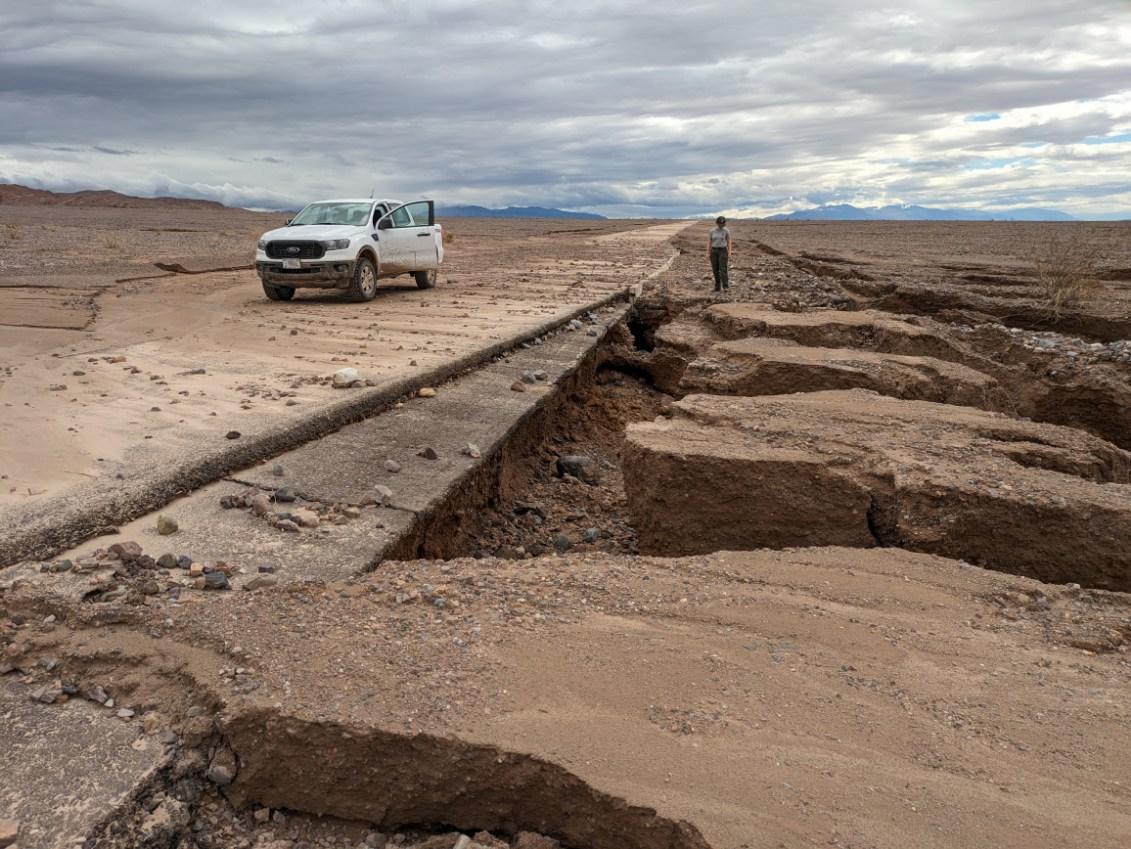 A paved road mostly covered with mud and debris