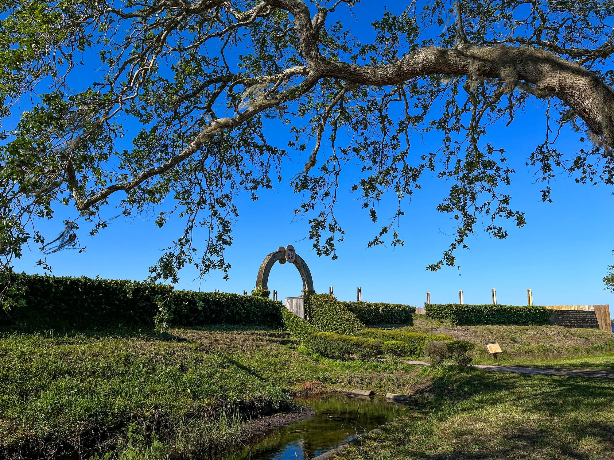Hedged fort wall and arched fort entrance lined with a moat