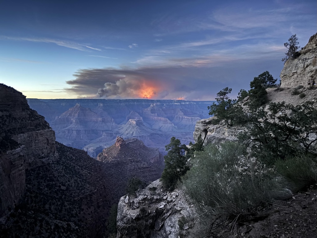 A large cloud of smoke looms over a barren landscape.
