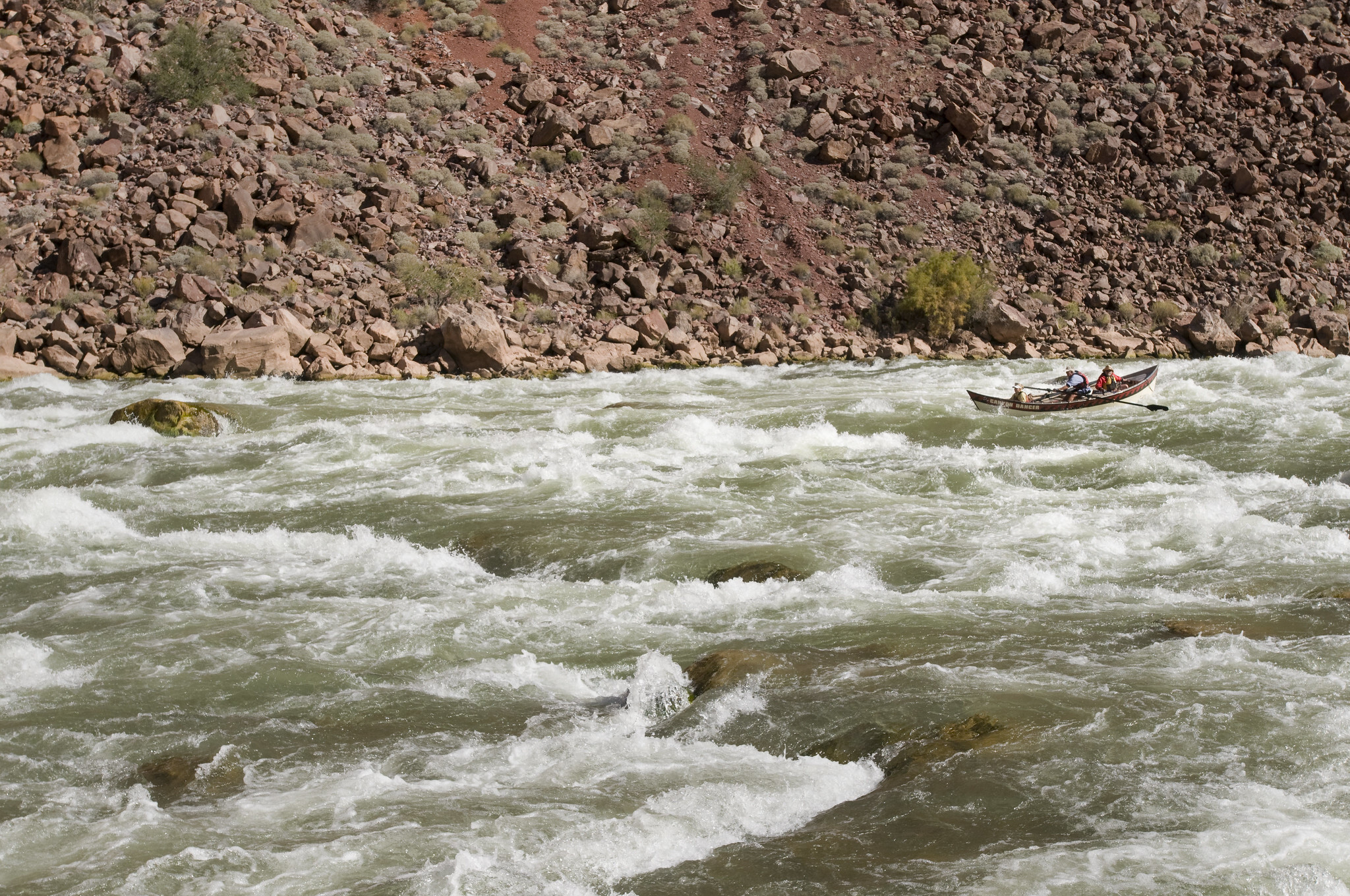 a dory maneuvering in rough water of Hance Rapid.