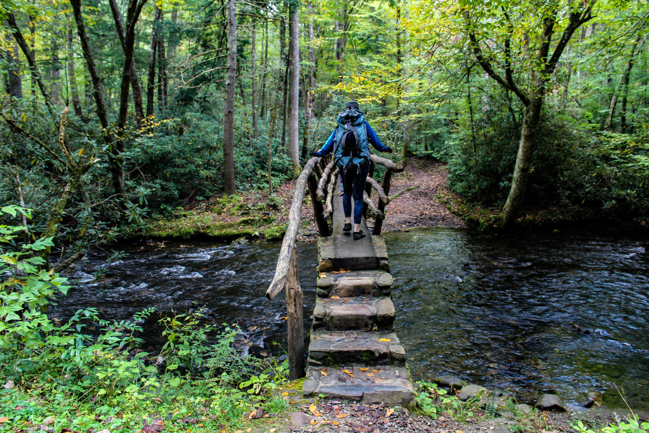 Hiker crossing a wooden bridge
