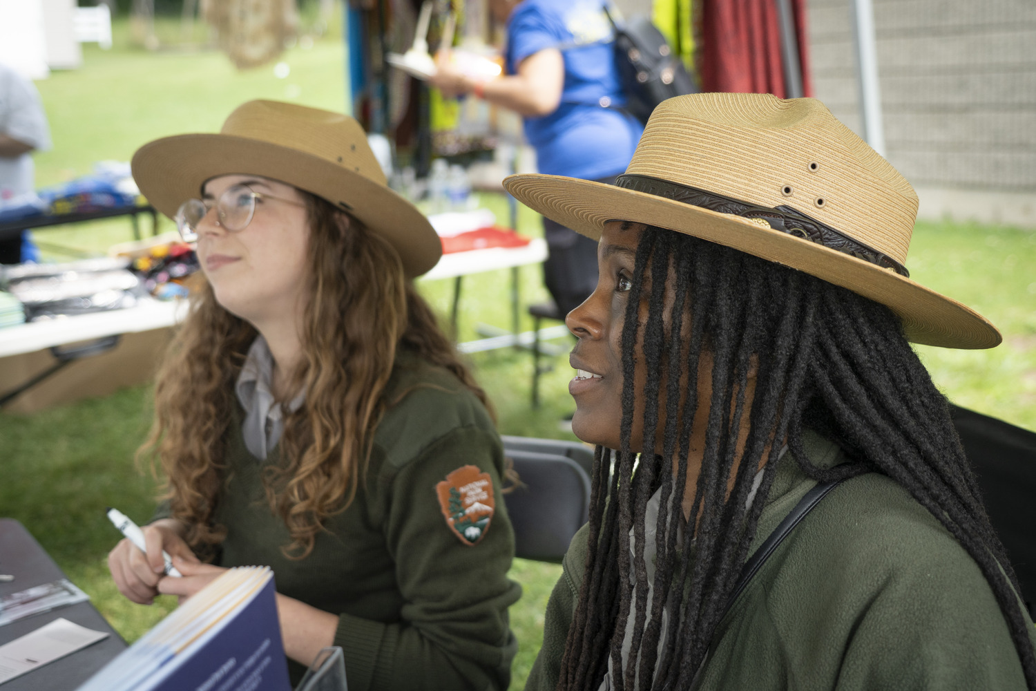 Two park rangers sit at a table at Harriet Tubman National Historical Park to offer information to visitors