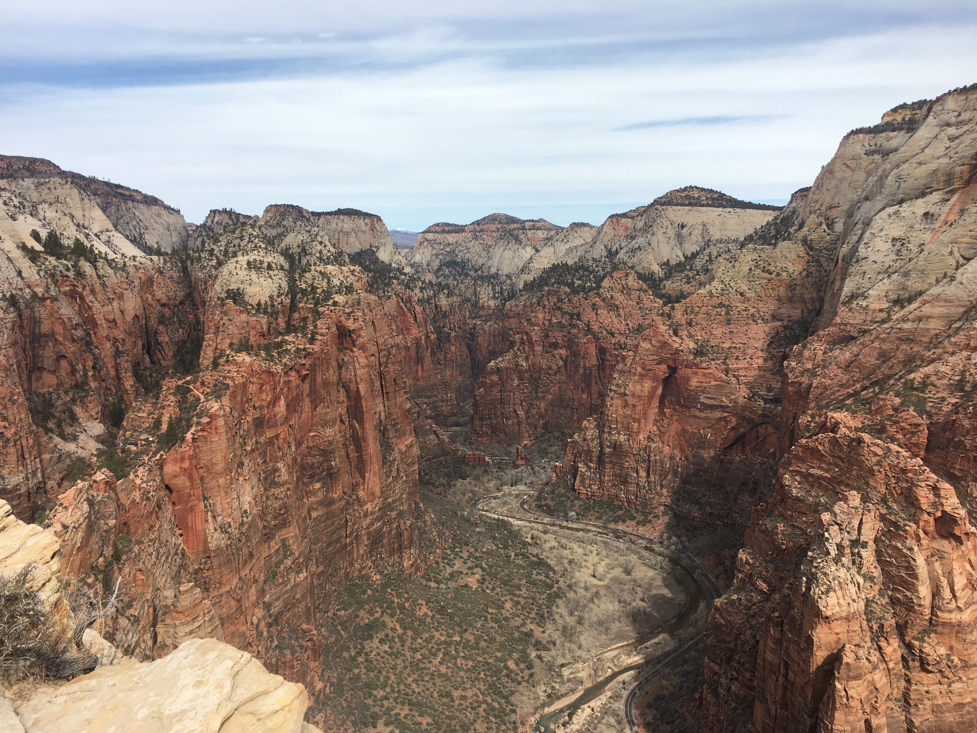 a view looking over a valley with sheer red rock cliffs on either side