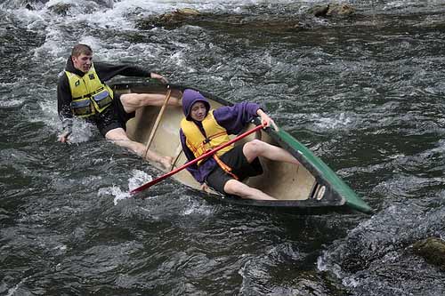 Two men in canoe tipping over.