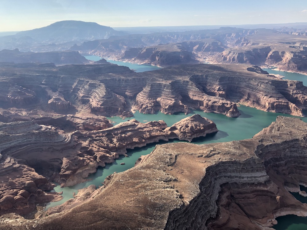 Lake Powell reaches inside layered canyons. Navajo Mountain in background / NPS Mountain with layered canyons and lake