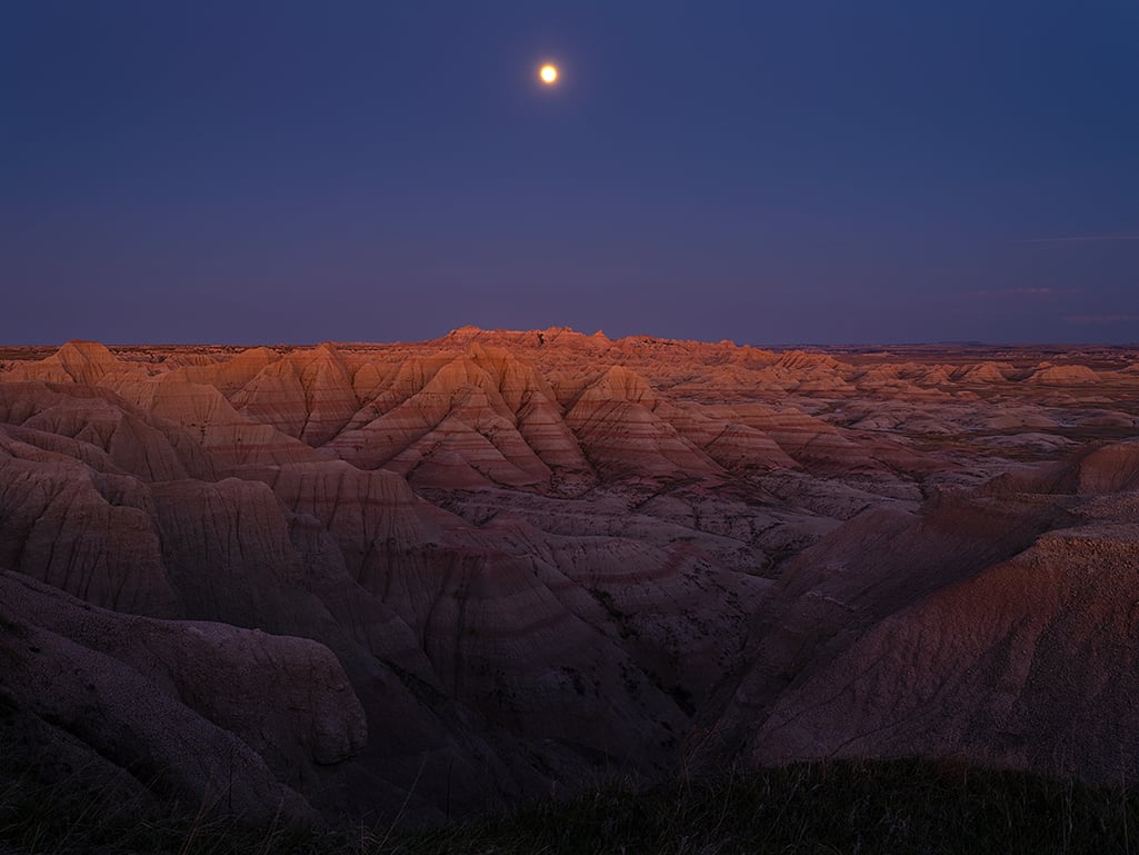 Sunset alpenglow and a full moon at Panorama Point, Badlands National Park / Rebecca Latson