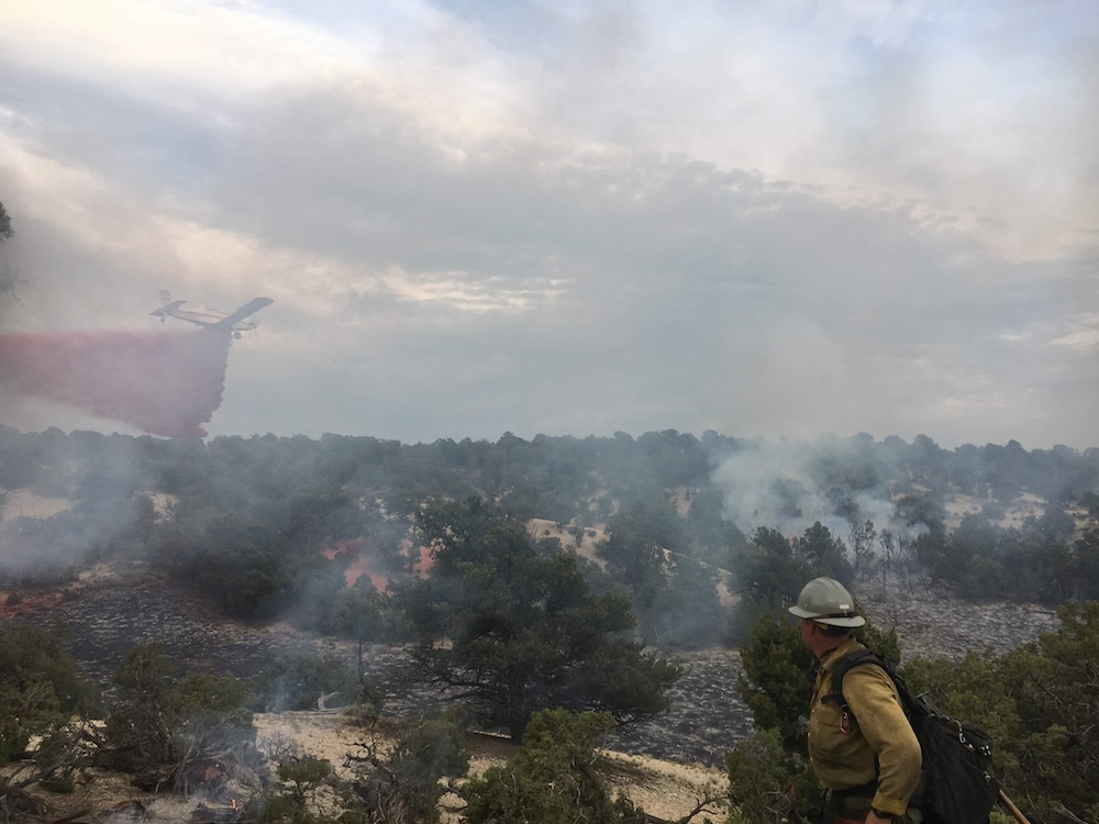 A National Park Service firefighter watches a single engine air tanker drop fire retardant on the East Seep Fire in 2022 in Utah / NPS A National Park Service firefighter watches a single engine air tanker drop fire retardant on the East Seep Fire in 2022 in Utah / NPS