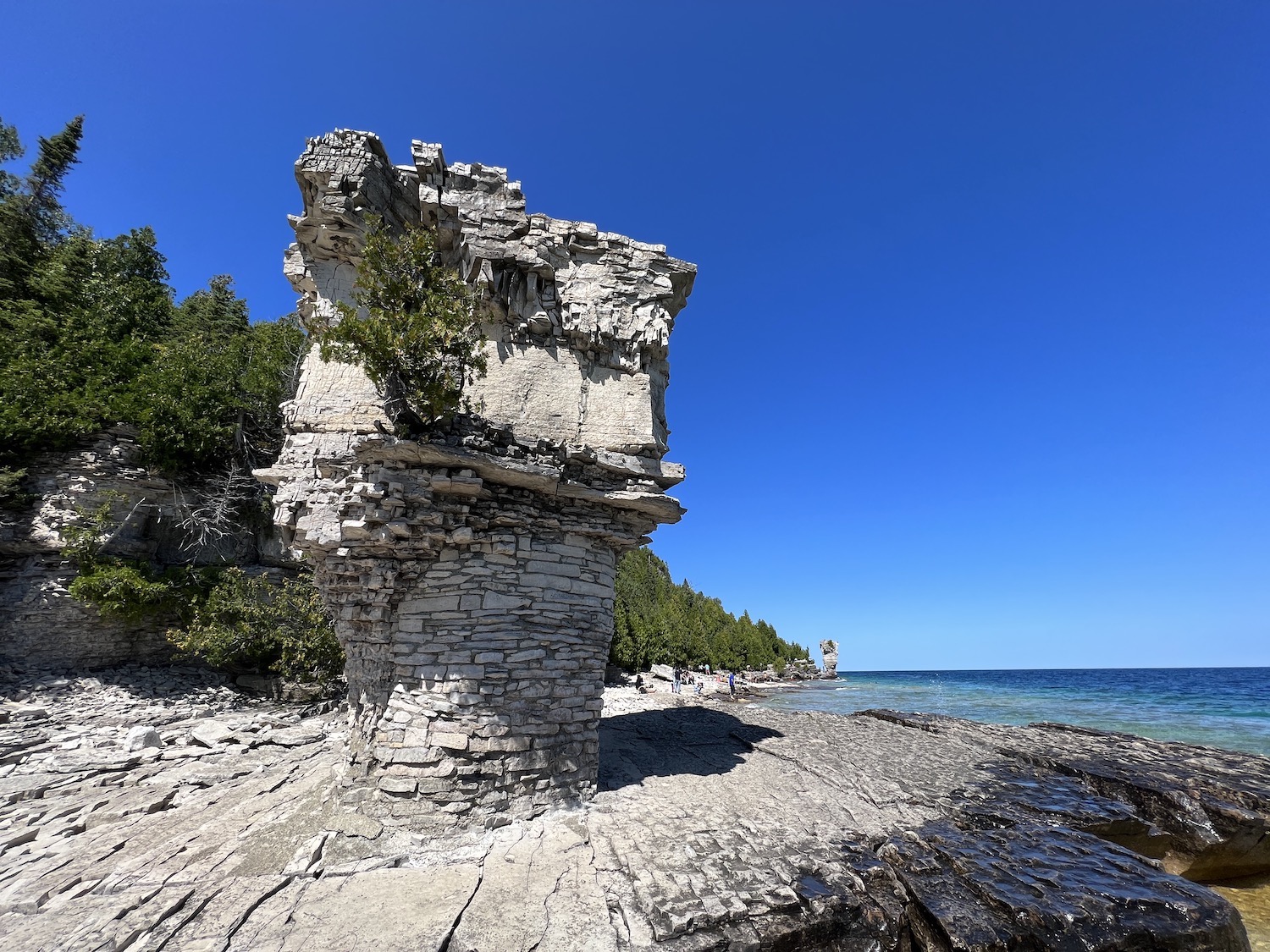 Small Flowerpot stands on the shore of Flowerpot Island in front of Big Flowerpot. Small Flowerpot stands on the shore of Flowerpot Island in front of Big Flowerpot.