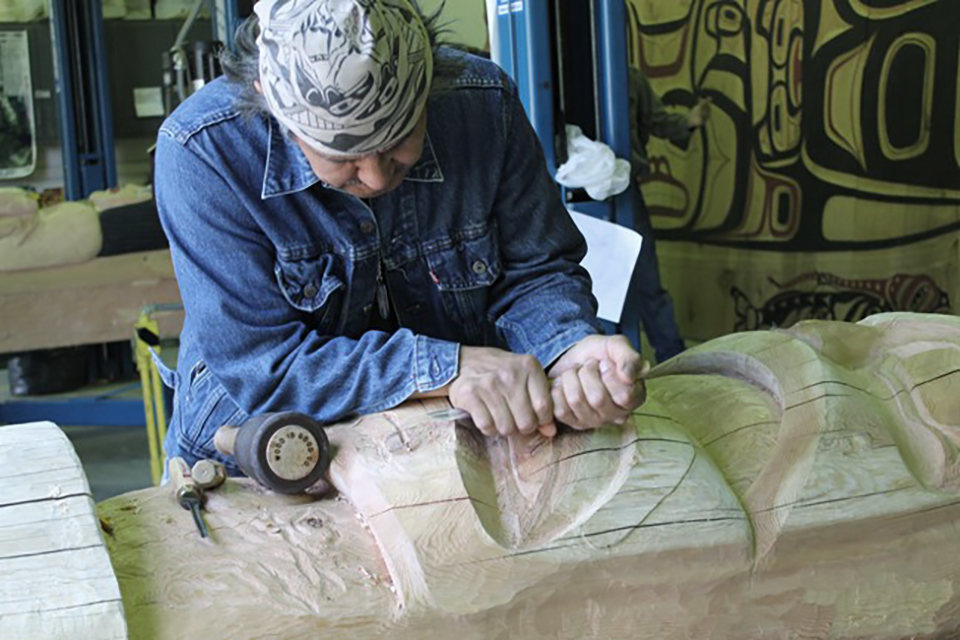 A carver working on the Wooshkeetaan House post, Glacier Bay National Park and Preserve / National Park Service