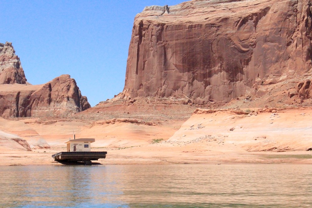 Changing lake levels has left this floating restroom stranded on rock. The bathroom, once located near Dominguez Butte has been moved to deeper water as of June 2021/NPS