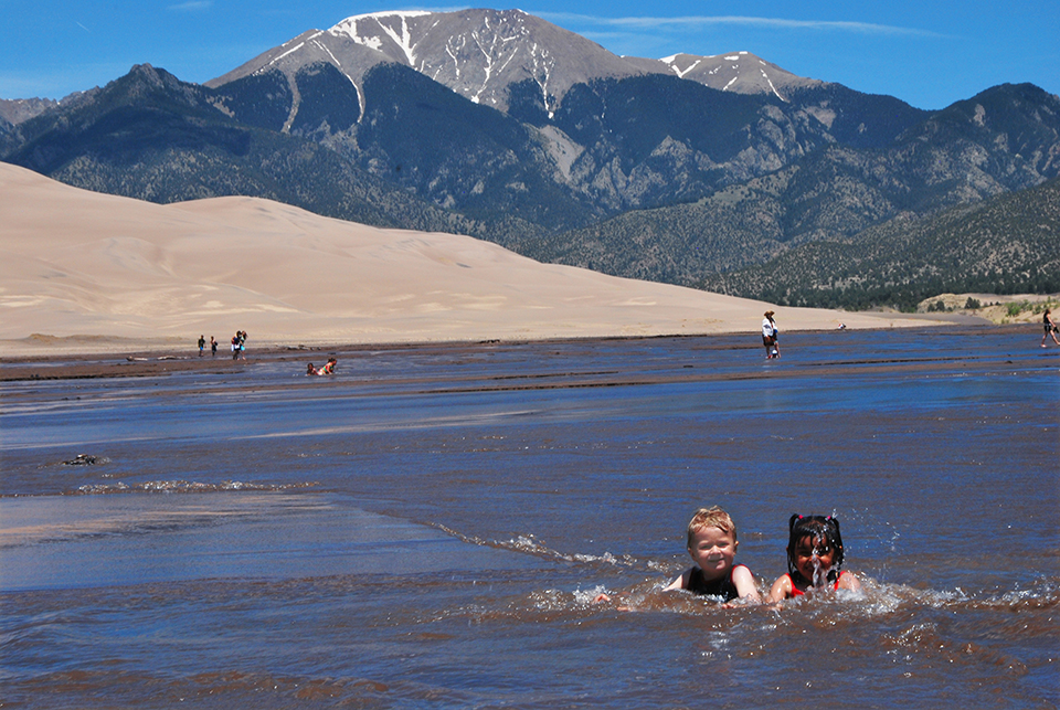Having fun in Medano Creek, Great Sand Dunes National Park and Preserve / National Park Service