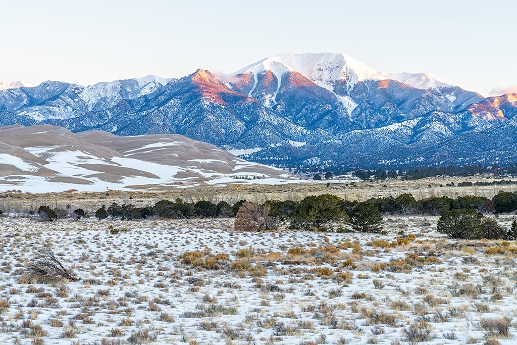 Sunrise over the mountains as seen from the rear of the visitor center, Great Sand Dunes National Park and Preserve / Rebecca Latson