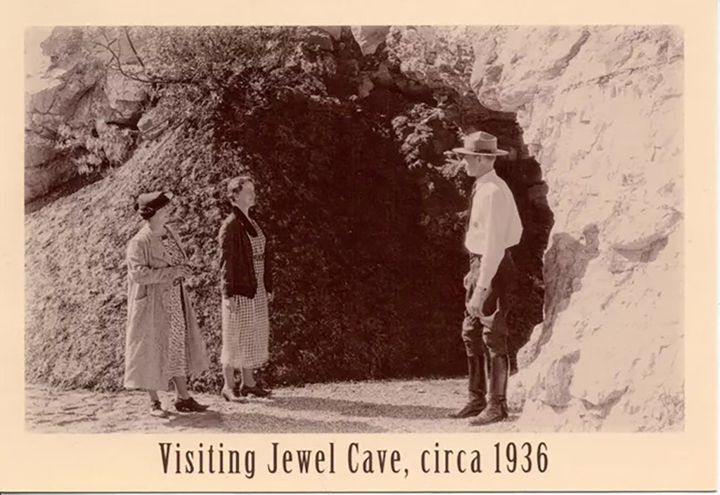 A 1936 postcard of a ranger and visitors at Jewel Cave's historic entrance, Jewel Cave National Monument / NPS file A 1936 postcard of a ranger and visitors at Jewel Cave's historic entrance, Jewel Cave National Monument / NPS file