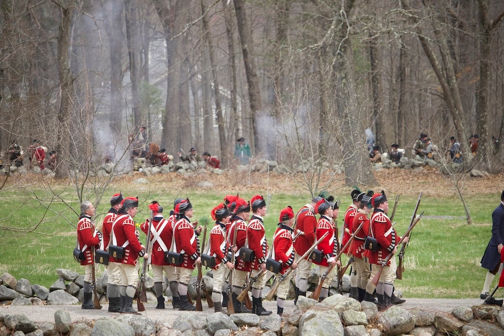 British soldier reenactors formed in a column march along Battle Road while fending off the colonial militia/Marcus Wolf British soldier reenactors formed in a column march along Battle Road while fending off the colonial militia/Marcus Wolf