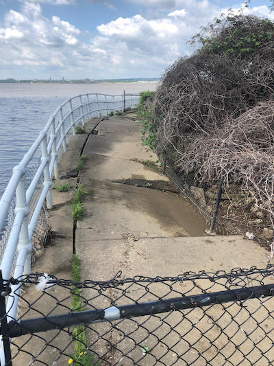 A chain link fence blocks access to a 60-foot section of East Potomac Park, part of the National Mall where deteriorating sidewalk and seawall have made it unsafe/NPS