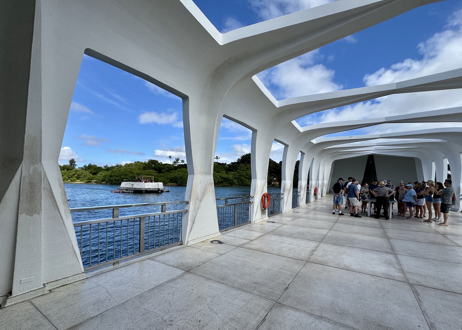 A ranger speaks to visitors on the USS Arizona Memorial as a historic preservation team works on a nearby mooring quay. A ranger speaks to visitors on the USS Arizona Memorial as a historic preservation team works on a nearby mooring quay.