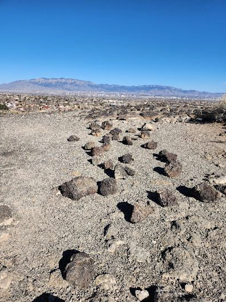 Volcanic rocks scattered across the mesa top after being removed from an archeological site/NPS