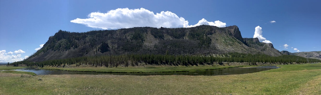 Panoramic of the West Yellowstone rhyolite lava flow taken along Highway 20 (between the West entrance of Yellowstone National Park and Madison Junction). The flow is approximately 111,000 years old and has a volume of about 41 km3 (10 mi3). Panoramic of the West Yellowstone rhyolite lava flow taken along Highway 20 (between the West entrance of Yellowstone National Park and Madison Junction). The flow is approximately 111,000 years old and has a volume of about 41 km3 (10 mi3).