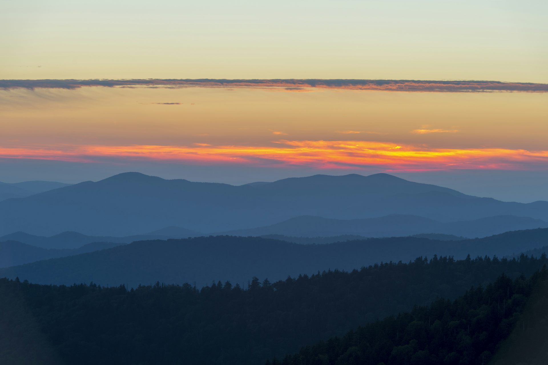 The sun sets on a range of mountains.