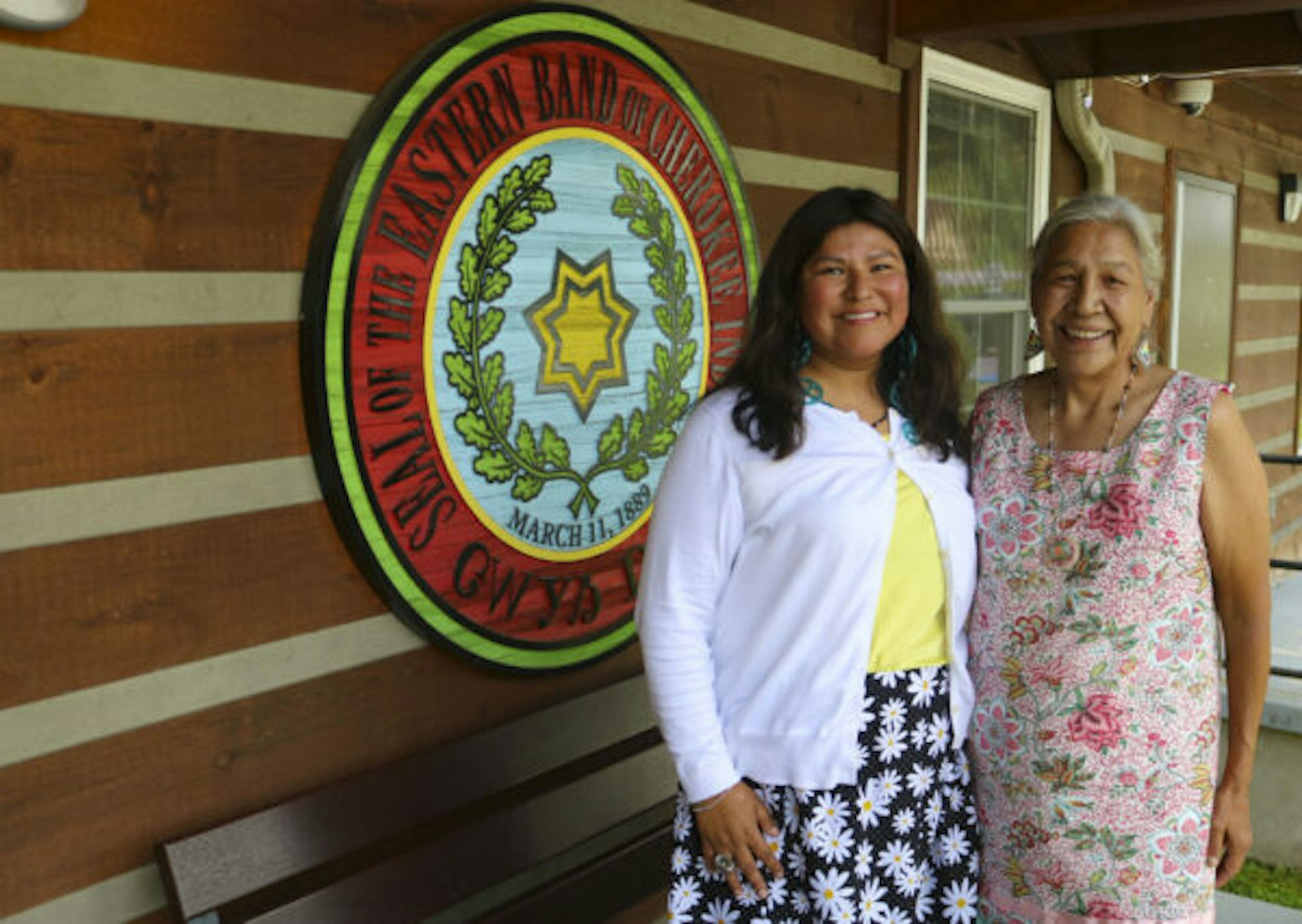Two Cherokee women stand next to each other as they pose for a photograph.