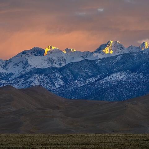 A telephoto sunrise over the mountains at Great Sand Dunes National Park by Rebecca Latson