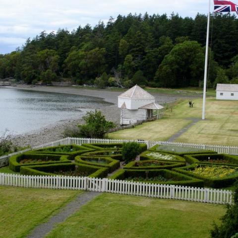 Looking out over a manicured, sculpted garden and historic buildings at San Juan National Historical Park