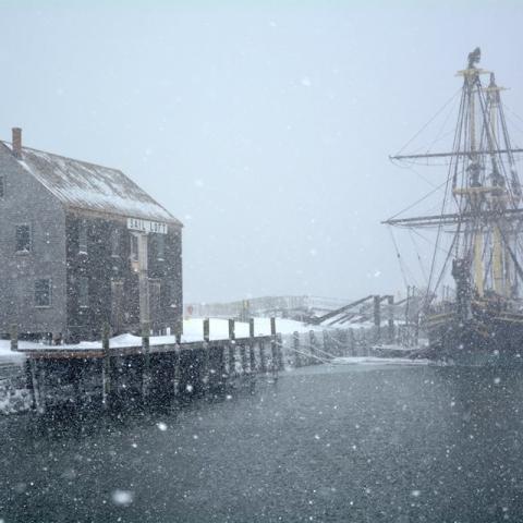 A replica of the ship Friendship docked in the water during a snowstorm, Salem Maritime National Historic Site