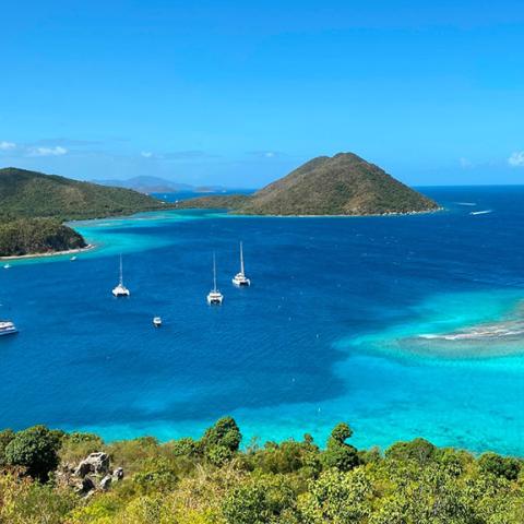 A view overlooking a bay of turquoise-blue water surrounded on three sides by beaches and tropical trees, Virgin Islands National Park