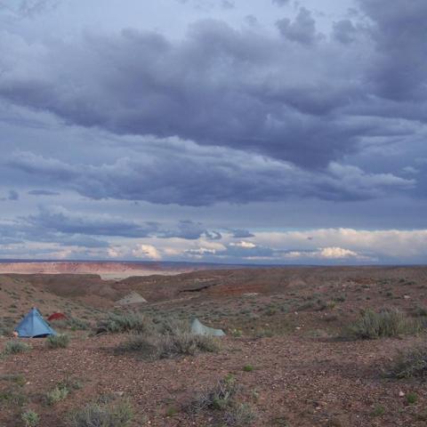 Tents set up in the backcountry of Wupatki National Monument on a cloudy overcast day