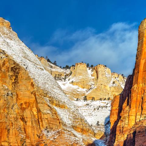 A telephoto close-up of a sunrise over rock formations and steep canyon walls at Zion National Park in Utah