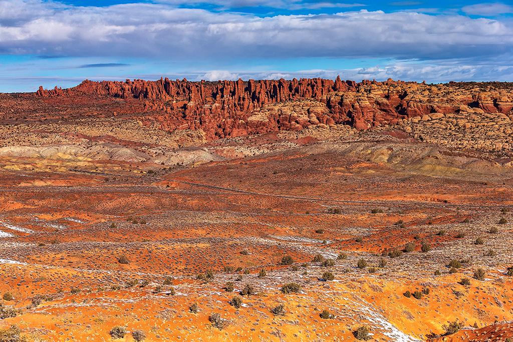 A sunny view of Salt Valley with the formations of Fiery Furnace in the distance at Arches National Park in Utah