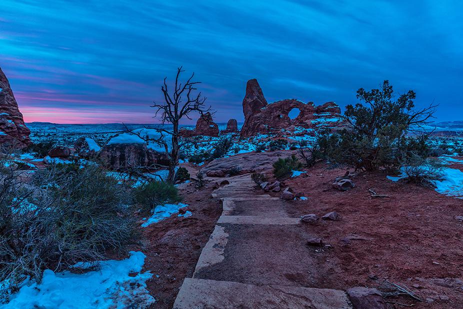 Blue hour and the beginning of sunrise on a cloudy New Year's Eve morning over Turret Arch in Arches National Park, Utah