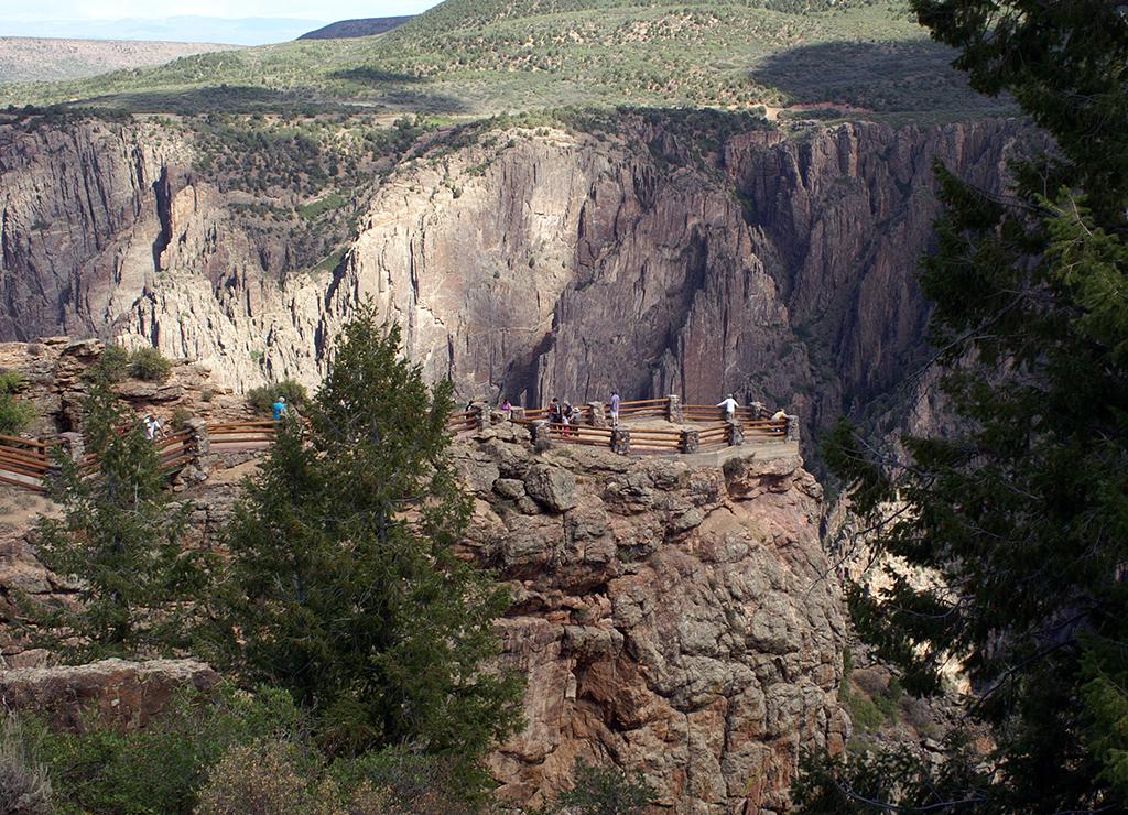 People standing within a small fenced area overlooking the Black Canyon at Black Canyon of the Gunnison National Park