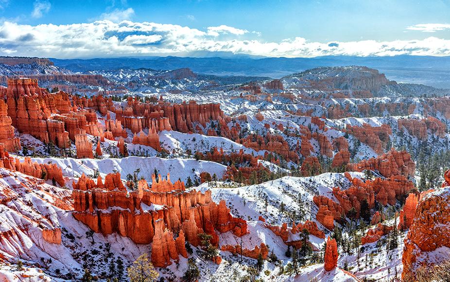 Sunshine, clouds, and spring snow on the red rock hoodoos of Bryce Canyon National Park, Utah