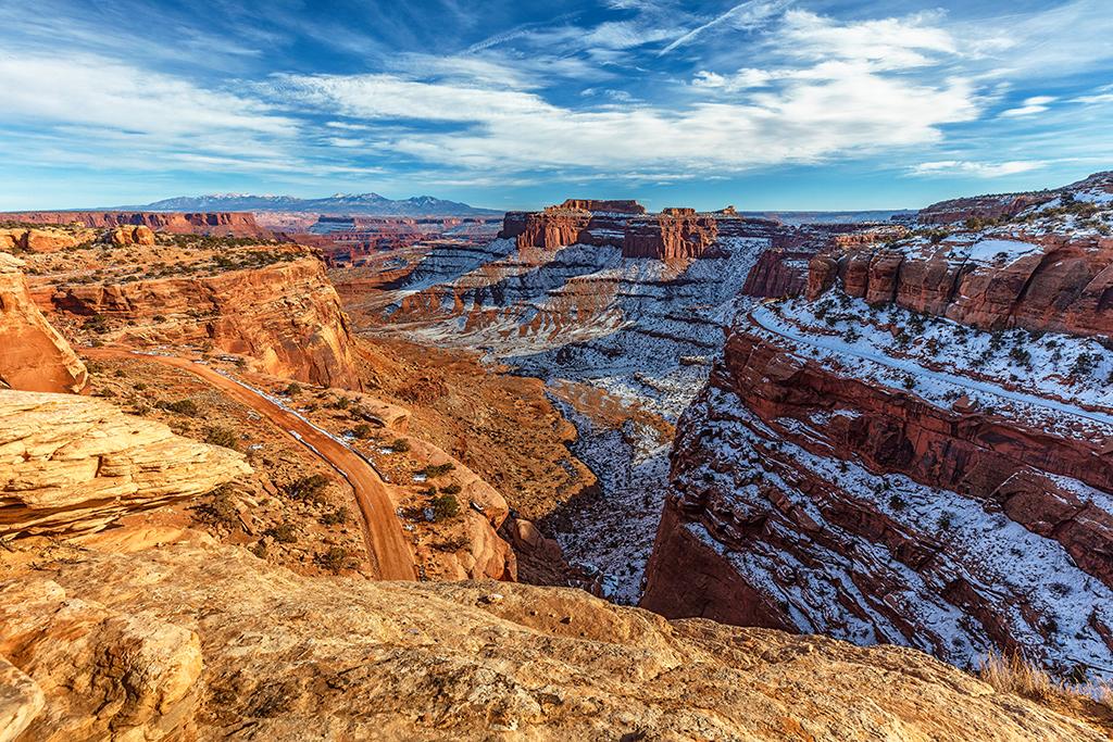 A winter afternoon view into the partially sunny, partially shaded steep red-rock walls of Shafer Canyon in the Island in the Sky District of Canyonlands National Park