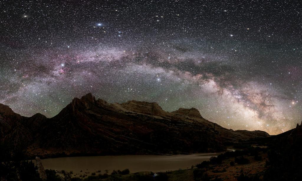 The Milky Way arcs over the dramatic rock formations of Mitten Park Fault along the Green River at Dinosaur National Monument, Utah.