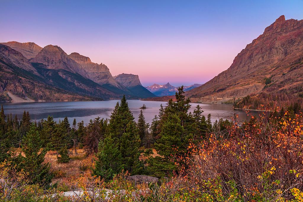 Morning colors of pink and blue mixed with autumn colors of gold and red at the Wild Goose Island view area on St. Mary Lake, Glacier National Park