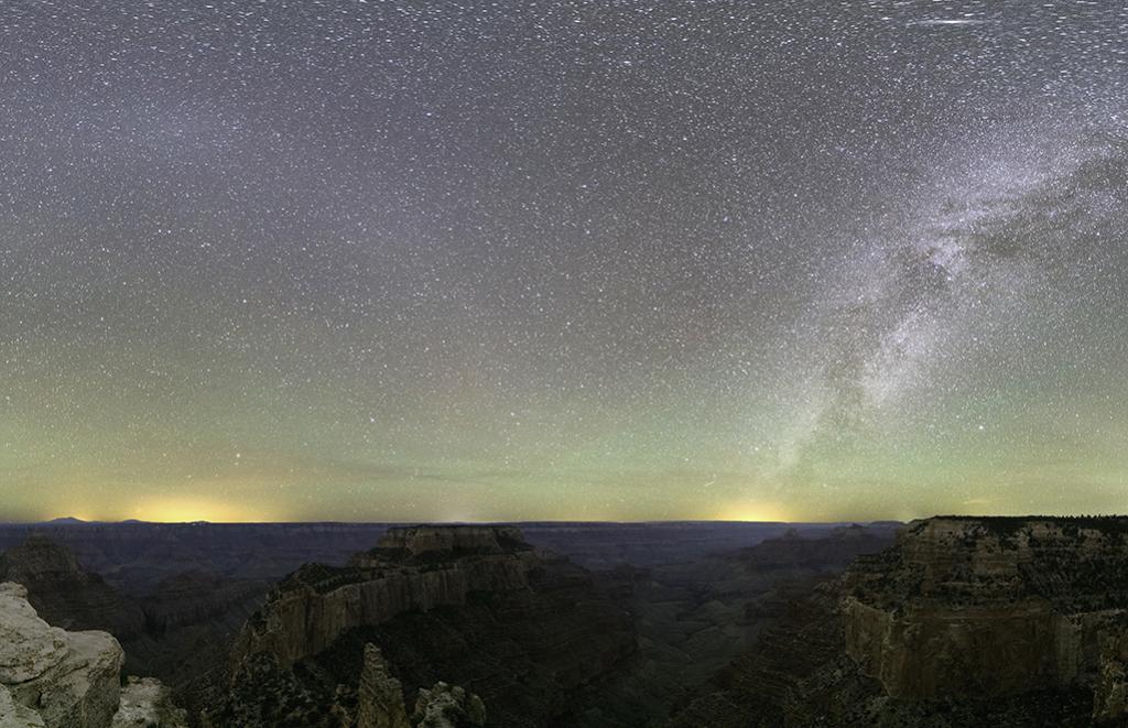 The Milky Way illumines an opalescent, dusk night sky with views to dramatic rock formations from Cape Royal Trail at the North Rim of Grand Canyon National Park, Arizona.