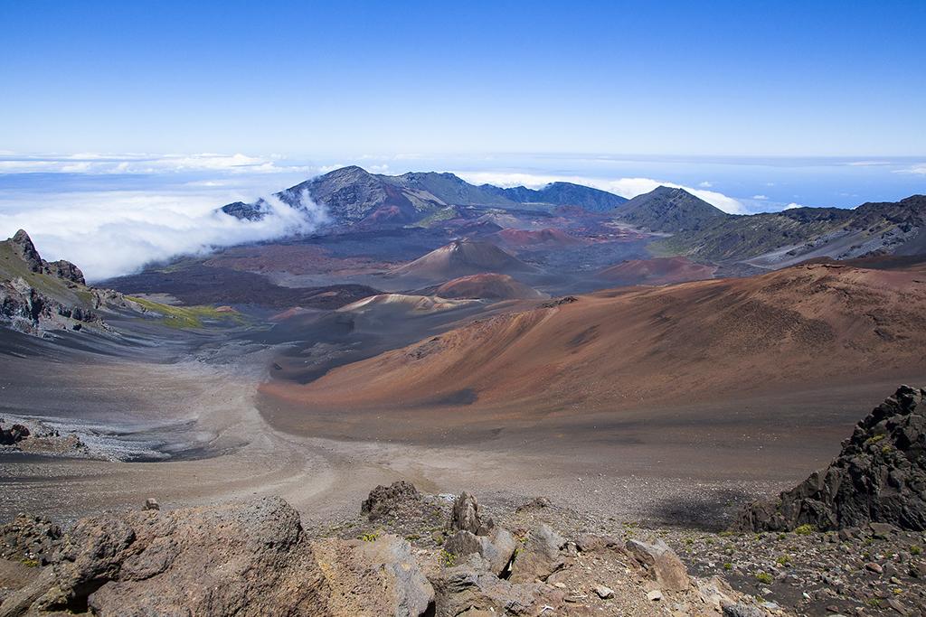 A wide-angle vista of clouds, cinder cones and other volcanic scenery in Haleakala National Park in Hawaii