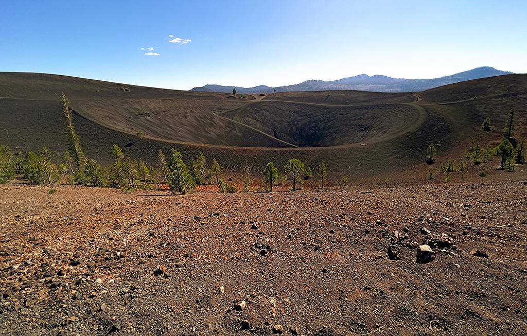 An ultra-wide-angle view of the top of Cinder Cone crater with a clear blue sky above, Lassen Volcanic National Park