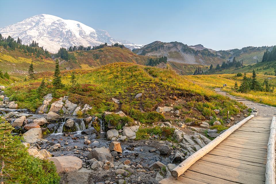 Edith Creek and the footbridge over the creek with Mount Rainier in the background at the Paradise area of Mount Rainier National Park, in Washington state