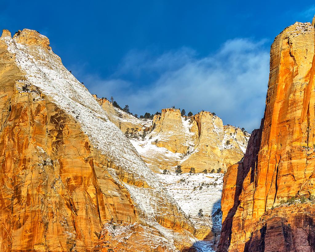 A telephoto close-up of a sunrise over rock formations and steep canyon walls at Zion National Park in Utah