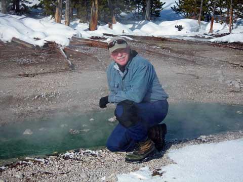 Scientist next to hot spring at Yellowstone.