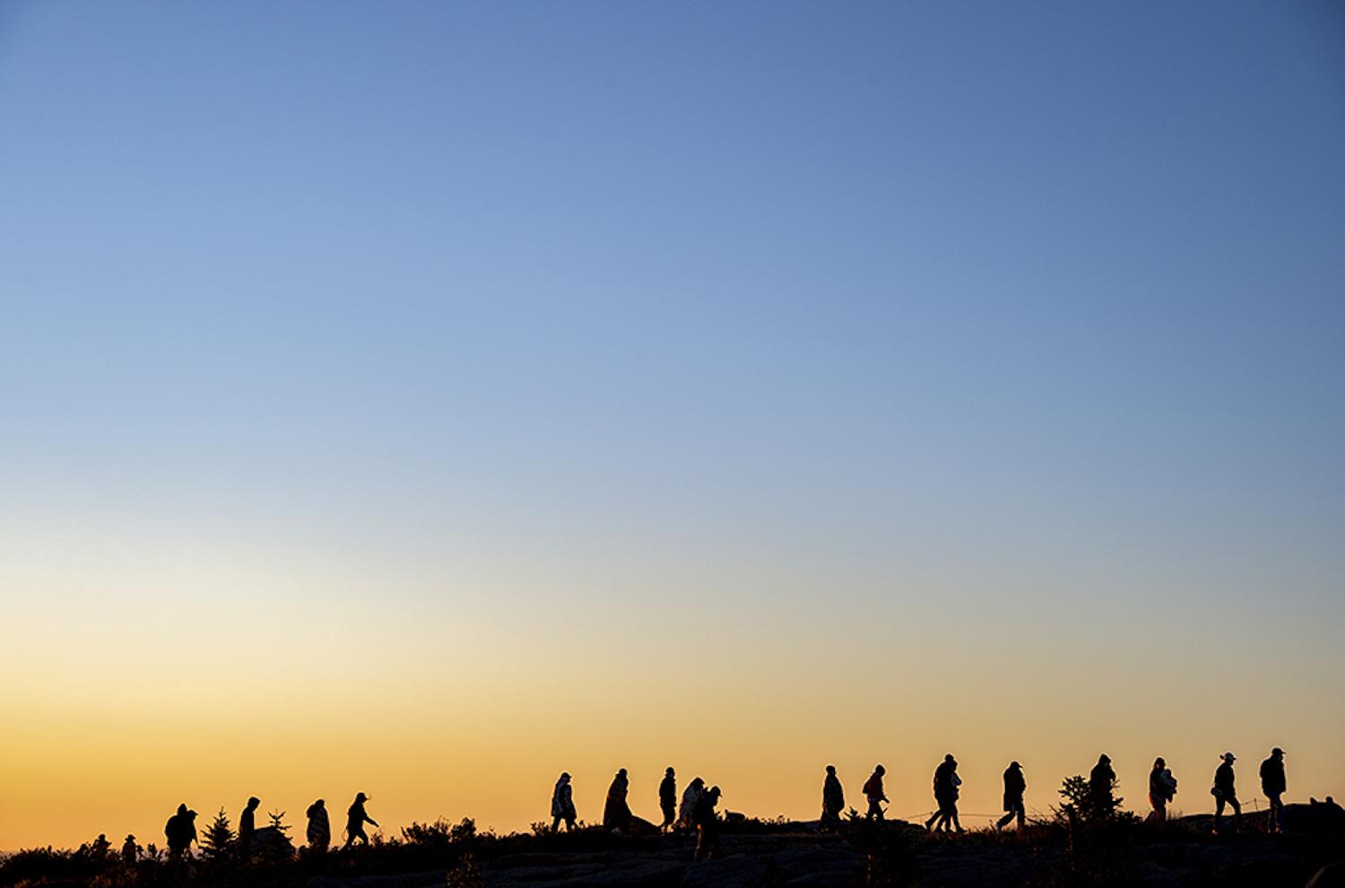 Park visitors walk from the summit of Cadillac mountain after watching the sun rise in Acadia National Park. (Photo by Will Newton/Friends of Acadia)