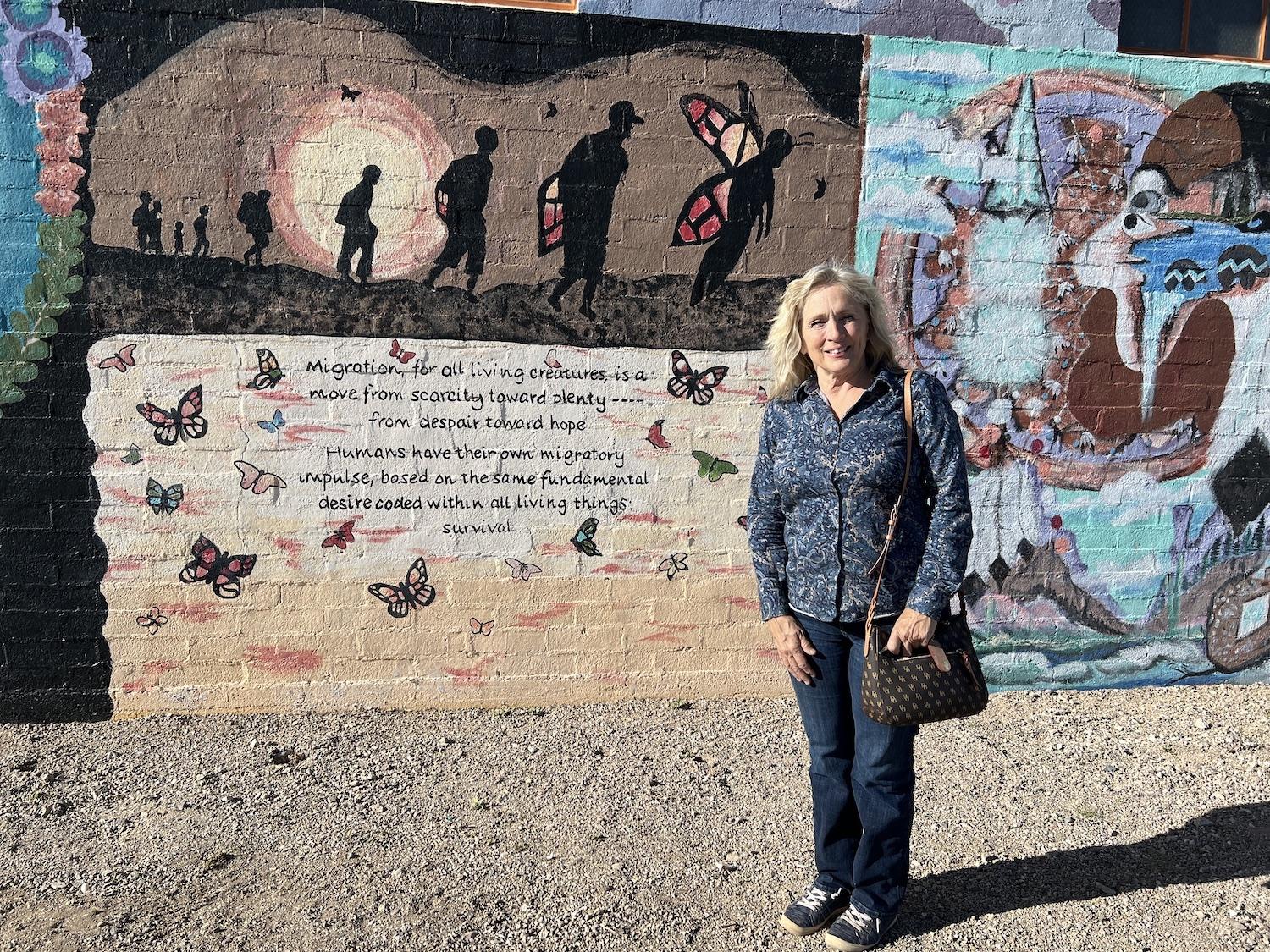 Ajo artist Maria Singleton stands by her mural that speaks to the complex issue of migration in the Borderlands of Arizona and Mexico.