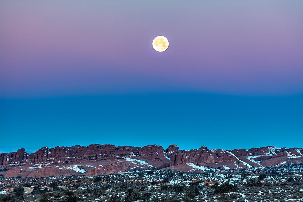 A super moonset and the beginning of sunrise, Arches National Park / Rebecca Latson