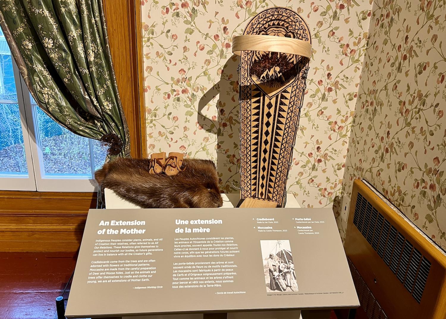 In the nursery, a wooden cradleboard, baby moccasins and a beaver pelt speak to the way that Indigenous Peoples consider plants, animals and "All of Creation" to be relatives. 