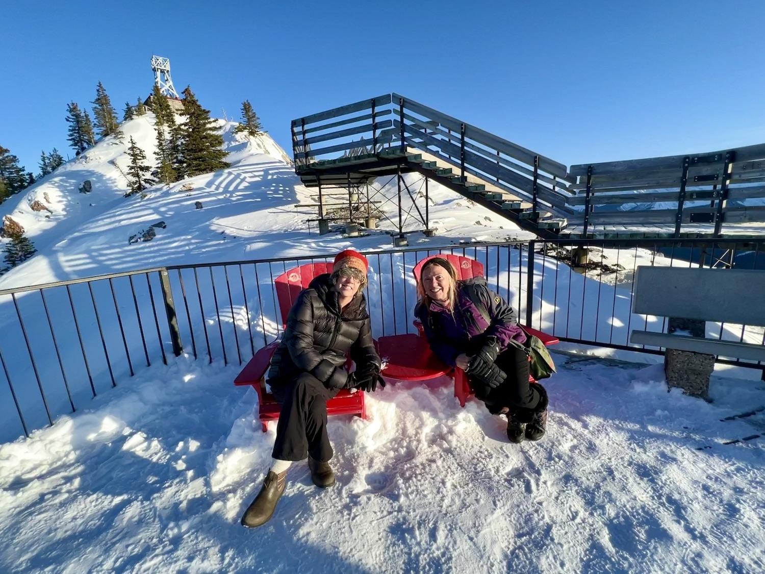 Under what's left of the Sulphur Mountain Cosmic Ray Station National Historic Site and a 1903 weather observatory, Jennifer Bain and Maureen Littlejohn sit in two of the red chairs that Parks Canada places in scenic spots across the country