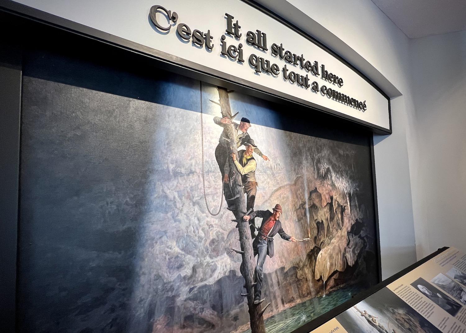 A mural depicts the three railway workers credited with rediscovering the cave and thermal springs.